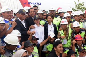 Presiden Jokowi didampingi Ibu Negara Iriana dan Menteri BUMN berfoto bersama para pekerja yang menyelesaikan pembangunan jalan tol Trans Jawa, di Jembatan Kali Kuto, Semarang, Jateng, Kamis (20/12). (Foto: OJI/Humas)