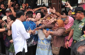 Warga Keluarahan Kalianya, Tambora, Jakarta Barat, berebut untuk bisa bersalaman dengan Presiden Jokowi, yang meninjau pelaksanaan Mekaar di Lapangan Persima. (Foto: JAY/Humas)