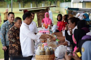 Presiden Jokowi membeli produk peserta program Mekaar, di Stadion Gongseng, Cijantung, Jakarta Timur, Kamis (10/1) sore. (Foto: OJI/Humas)