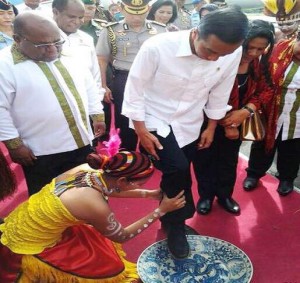 Presiden Jokowi didampingi Ibu Negara Iriana dan Gubernur Papua Lukas Enembe mengikuti upacara adat saat tiba di Bandara Sentani, Jayapura, Sabtu (27/12) siang