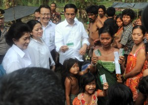 Presiden Jokowi didampingi Menko PMK dan Menkes menyerahkan KIS kepada Suku Anak Dalam, di Kab. Sarolangun, Jambi, Jumat (30/10). (Foto: Rusman/Setrpres)
