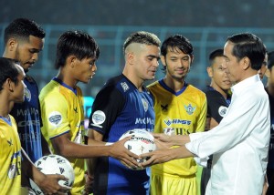 Presiden Jokowi membagikan bola kepada pemain Arema dan Persegres sebelum kick off Piala Jenderal Sudirman, di Malang, Jatim, Selasa (10/11) malam
