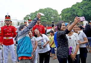 Photo Caption: People takes a selfie with Presidential Security Details on Sunday (28/8), at the front yard of the Merdeka Palace, Jakarta (9/8)