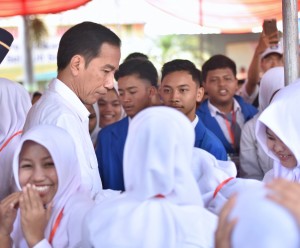 Presiden Jokowi di tengah siswa penerima KIP SMP Negeri 7, Jalan Cendrawasih, Kabupaten Jember, Minggu (13/8). (Foto: Humas/Agung)