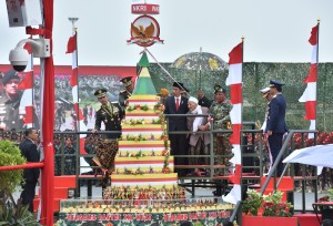 Presiden Jokowi melihat tumpeng pada perayaan HUT ke-72 TNI, di Dermaga Indah Kiat Cilegon, Provinsi Banten, Kamis (5/10). (foto: Humas/Jay)
