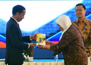 President Jokowi receives a book titled the 2018 Indef Economy Projection by Indef Director, Enny Sri Hartarti, at the Second Meeting of 100 Indonesian Economists, held at Puri Agung Convention Hall, Grand Sahid Jaya Hotel, Central Jakarta, Tuesday (12/12) morning. (Photo/Rahmat/PR)