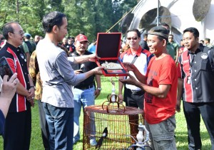 Presiden Jokowi menyerahkan hadiah kepada pemenang dalam acara Festival dan Pameran Burung Berkicau Piala Presiden Jokowi tahun 2018 di Kebun Raya Bogor, Minggu (11/3). (Foto: BPMI). 