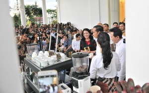 Presiden Jokowi dalam sebuah acara menikmati minum kopi bersama peserta.