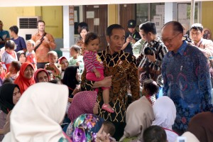 Presiden Jokowi menggendong seorang bocah saat mengajak Presiden Bank Dunia meninjau program penanganan stunting di SDN Tangkil 01, Kecamatan Caringin, Sukabumi, Jabar, Rabu (4/7) siang. (Foto: OJI/Humas)