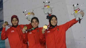 Tim beregu putri panjat tebing Indonesia mempertontonkan medali emas yang diraihnya setelah mengalahkan Tim China, di final yang digelar di SC Sport Climbing, Palembang, Senin (27/8) malam. (Foto: IST)