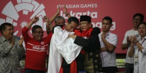Presiden Jokowi dan Ketua IPSI Prabowo Subianto bersama pesilat berpelukan bersama usai pertandingan pencak silat Asian Games yang digelar di Padepokan Pencak Silat, Taman Mini Indonesia Indah (TMII), Jakarta, Rabu (29/8). 