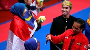 President Jokowi handled over the gold medal to Defia Rosmaniar, taekwondo athlete who won Indonesias first gold in 2018 Asian Games. (Photo: IST)