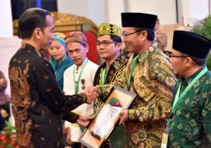 Presiden Jokowi menyerahkan sertifikat tanah perhutanan sosial dalam acara Rembug Nasional Performa Agraria, di Istana Negara, Jakarta, Kamis (20/9) pagi. (Foto: Rahmat/humas)
