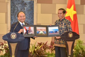 Presiden Jokowi berfoto bersama sembari menunjukkan foto-foto dokumentasi keduanya, di BNDCC, Nusa Dua, Bali, Jumat (12/10) pagi. (Foto: JAY/Humas)