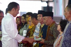 Presiden Jokowi menyerahkan sertifikat kepada warga di wilayah Jakarta Utara, di Lapangan C-04 Kawasan Berikat Nusantara, Marunda, Cilincing, Jakarta Utara, Rabu (17/10) sore. (Foto: OJI/Humas)