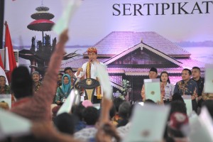 Presiden Jokowi menghitung sertifikat yang diterima warga, di di CB-1 Lapangan Tenis Indoor Komplek Perkantoran Pemerintah Kabupaten Lampung Tengah, Lampung, Jumat (23/11) siang. (Foto: JAY/Humas)