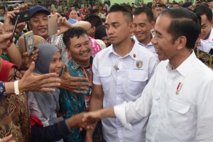 Presiden Jokowi menyambut uluran tangan warga saat menghadiri acara penyerahan 3.000 sertifikat hak tanah, di di GOR Tri Sanja, Tegal, Jawa Tengah, Jumat (9/11) pagi. (Foto: OJI/Humas)
