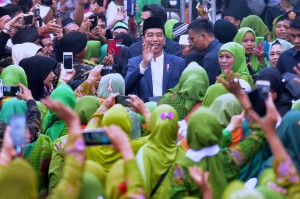 Presiden Jokowi menyapa para muslimat yang hadir dalam Hari Lahir Ke-73 Muslimat Nahdlatul Ulama (NU), di Stadion Utama GBK Senayan, Jakarta, Minggu (27/1) pagi. (Foto: Rahmat/Humas)