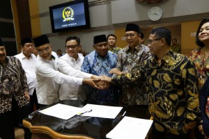 Minister of Religious Affairs and leaders of Commission VII DPR stack hands after the signing of 2019 hajj pilgrimage cost, at Indonesian Parliament Building, Jakarta, Monday (4/2). (Photo: PR of Ministry of Religious Affairs)