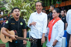 Presiden Jokowi dan Ibu Negara Iriana menyapa seorang penyanyi saat menikmati durian di Durian Si Bolang, Medan, Sumut, Sabtu (16/3) sore. (Foto: Dinda M/Humas)