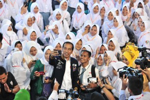 Presiden Jokowi berselfi ria bersama para siswa-siswi penerima KIP, di Gelanggang Olahraga David - Tonny, Limboto, Kabupaten Gorontalo, Kamis (1/3) siang. (Foto: JAY/Humas)