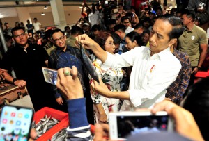 President Jokowi purchases a fish after inaugurating Muara Baru Modern Fish Market, at Koja, North Jakarta, Wednesday (13/3). (Photo: JAY/PR)