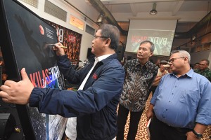 Minister of Communication and Informatics Rudiantara signs an exhibition poster at the 2018 Kilas Balik photo exhibition and book launch in Antara Photo Journalism Gallery, Jakarta, Friday (26/4).