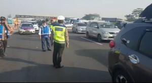 Officers monitor the implementation of One-way system at Cikampek tollgate, West Java, Thursday (30/5). (Photo by: Info Mudik 2019)