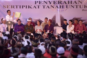 Presiden Jokowi menunjukkan isi sertifikat tanah saat menyerahkan 3.000 sertifikat tanah kepada rakyat, di Kecamatan Bangli, Kab. Bangli, Bali, Jumat (14/6) siang. (Foto: AGUNG/Humas) 